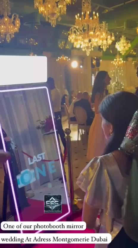 Guests posing at the EFS mirror booth under chandeliers